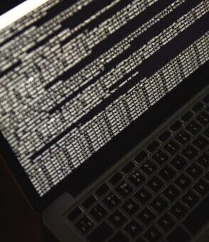 Hacking server. Close up photo of laptop screen with binary code. Cyber attack